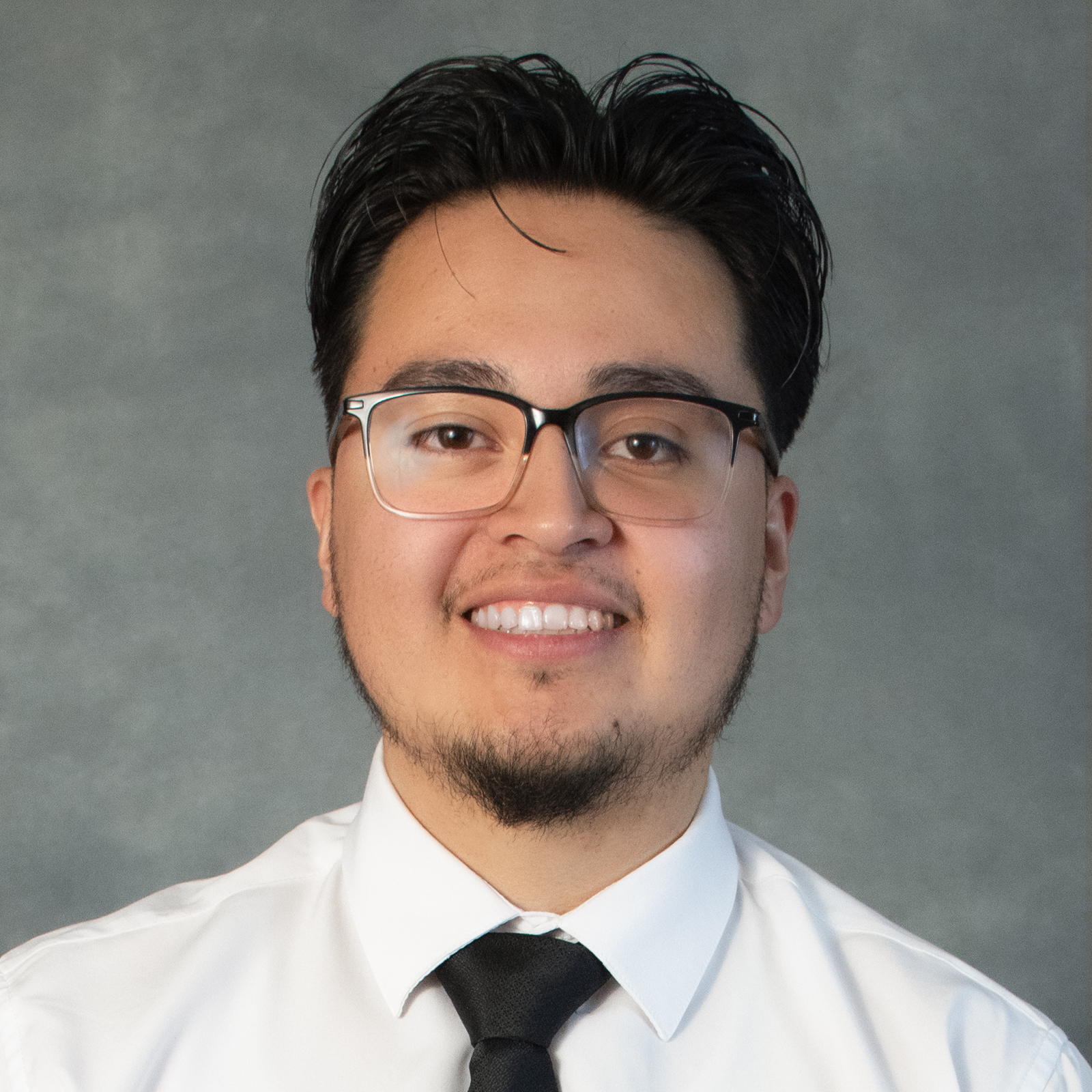 Guy  with short black hair wearing glasses, white shirt and black tie