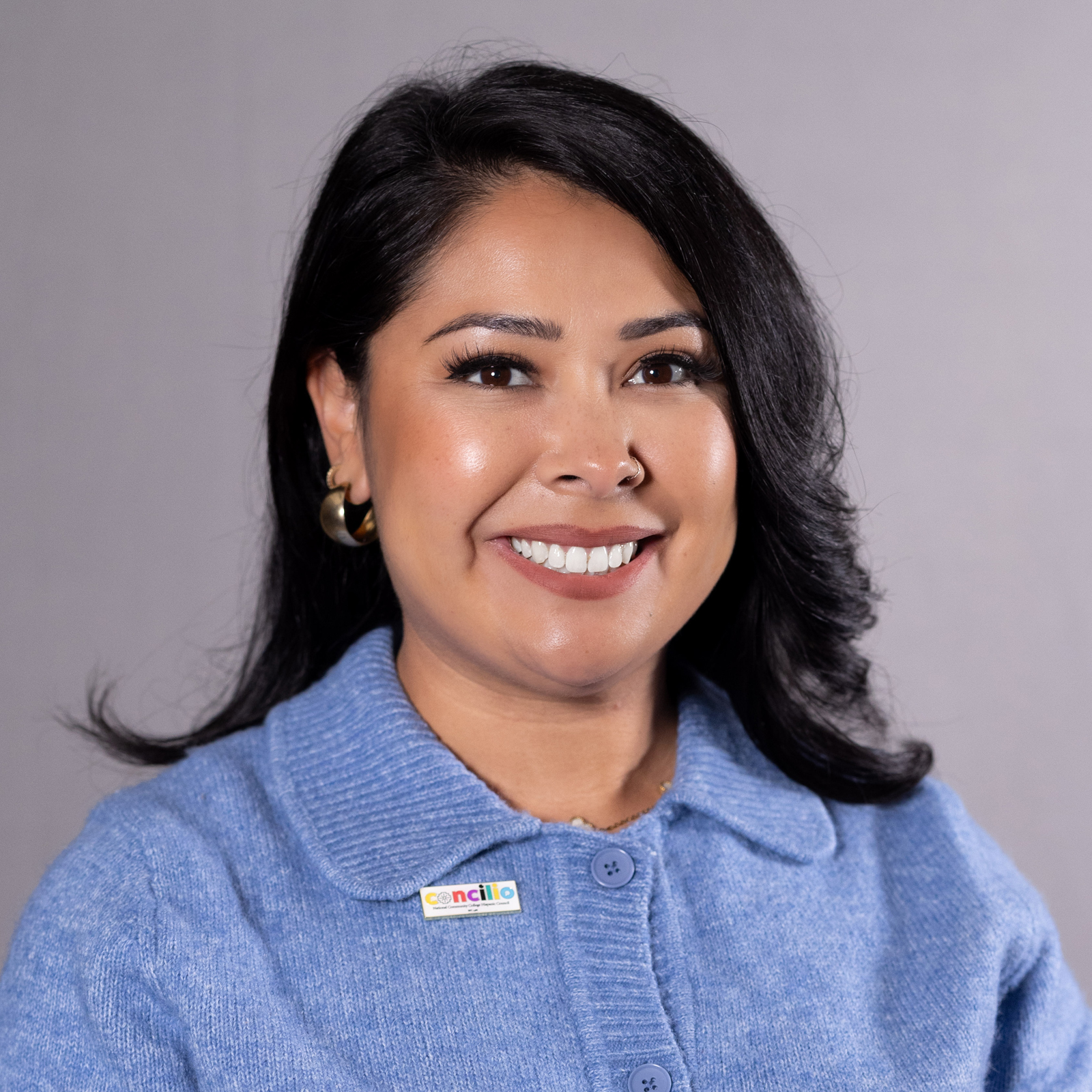 Woman with long dark hair wearing blue shirt 
