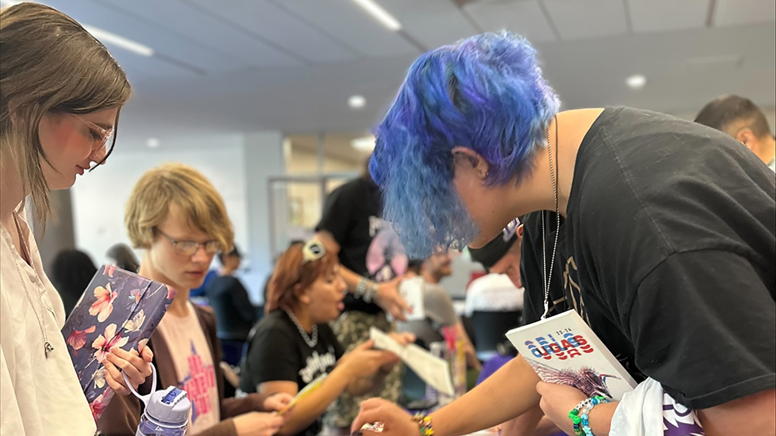 2 students at an event looking at a table