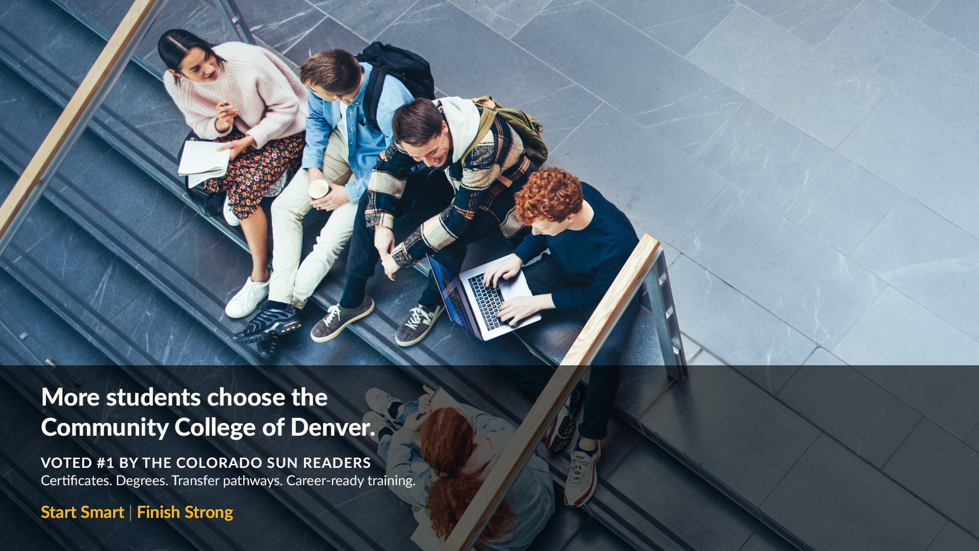 Group of 5 students sitting in a stairwell working 