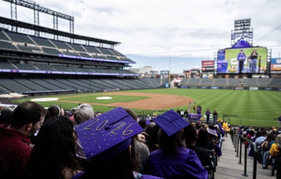 photo of a crowd at coors field for graduation, with a graduation cap that reads 2026