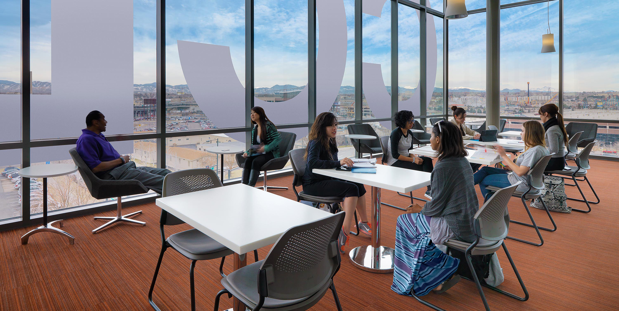 Group of students sitting in a study lounge in the Confluence building.