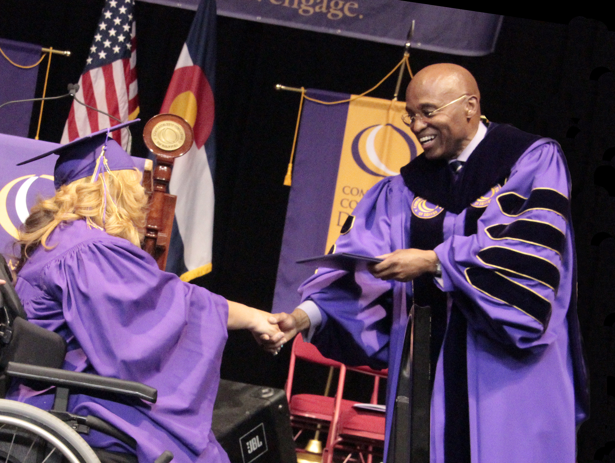 2014 female graduate in wheelchair receiving her diploma from CCD president Everette Freeman