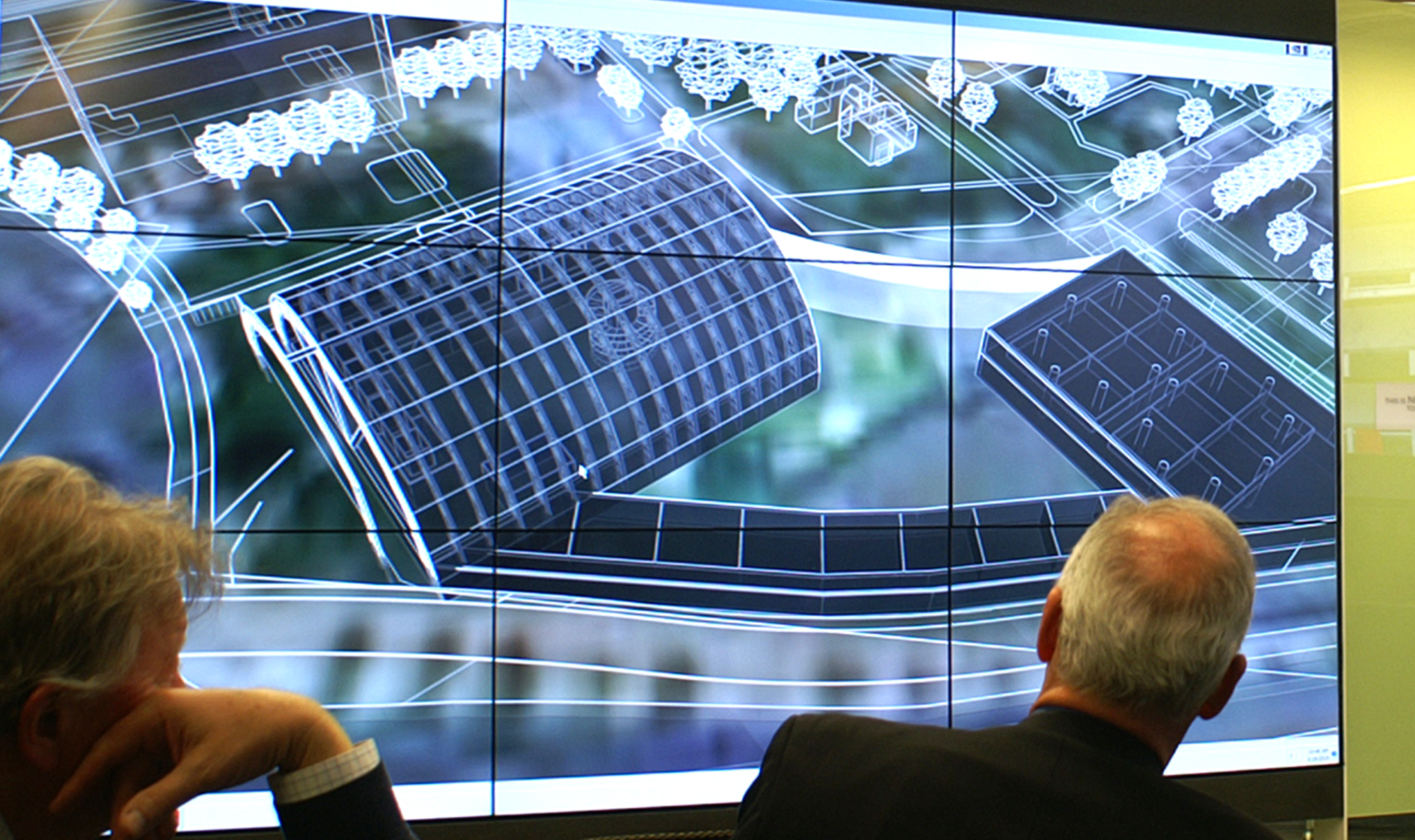 image of people looking at a large screen with architecture drawings
