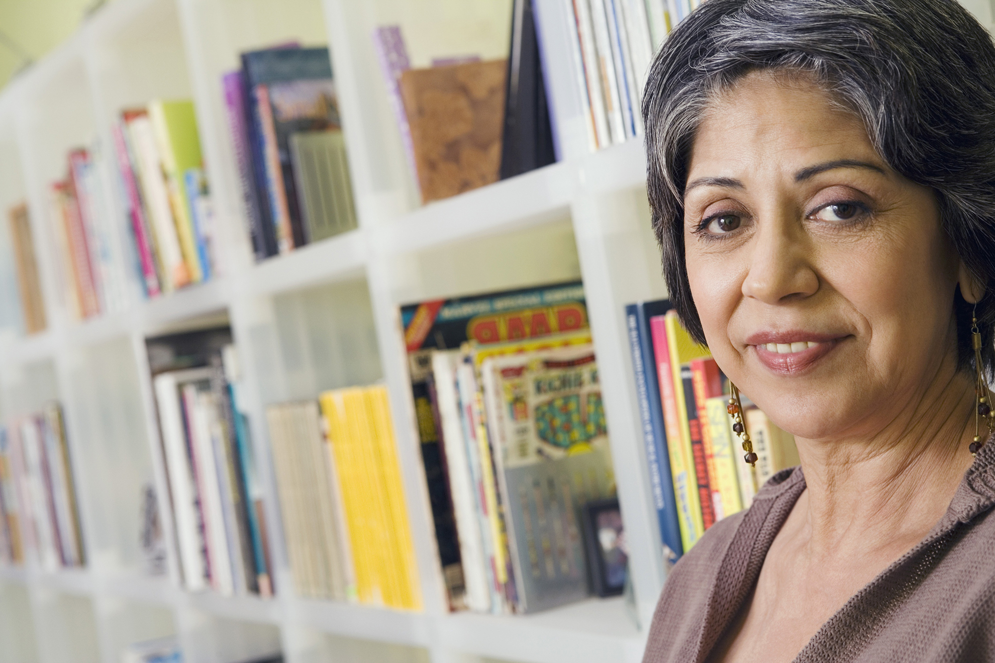 image of mature female student in front of bookshelf full of books