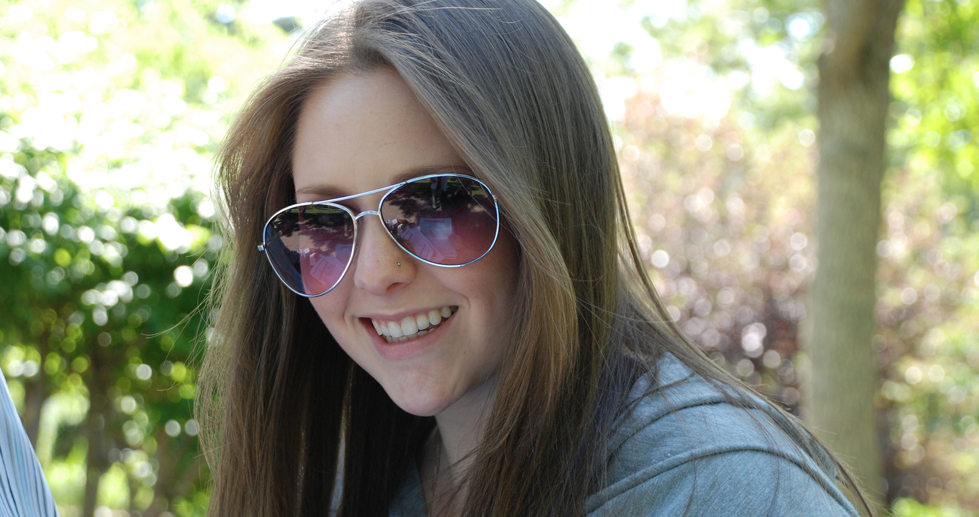 Young female student outside in sunglasses smiling