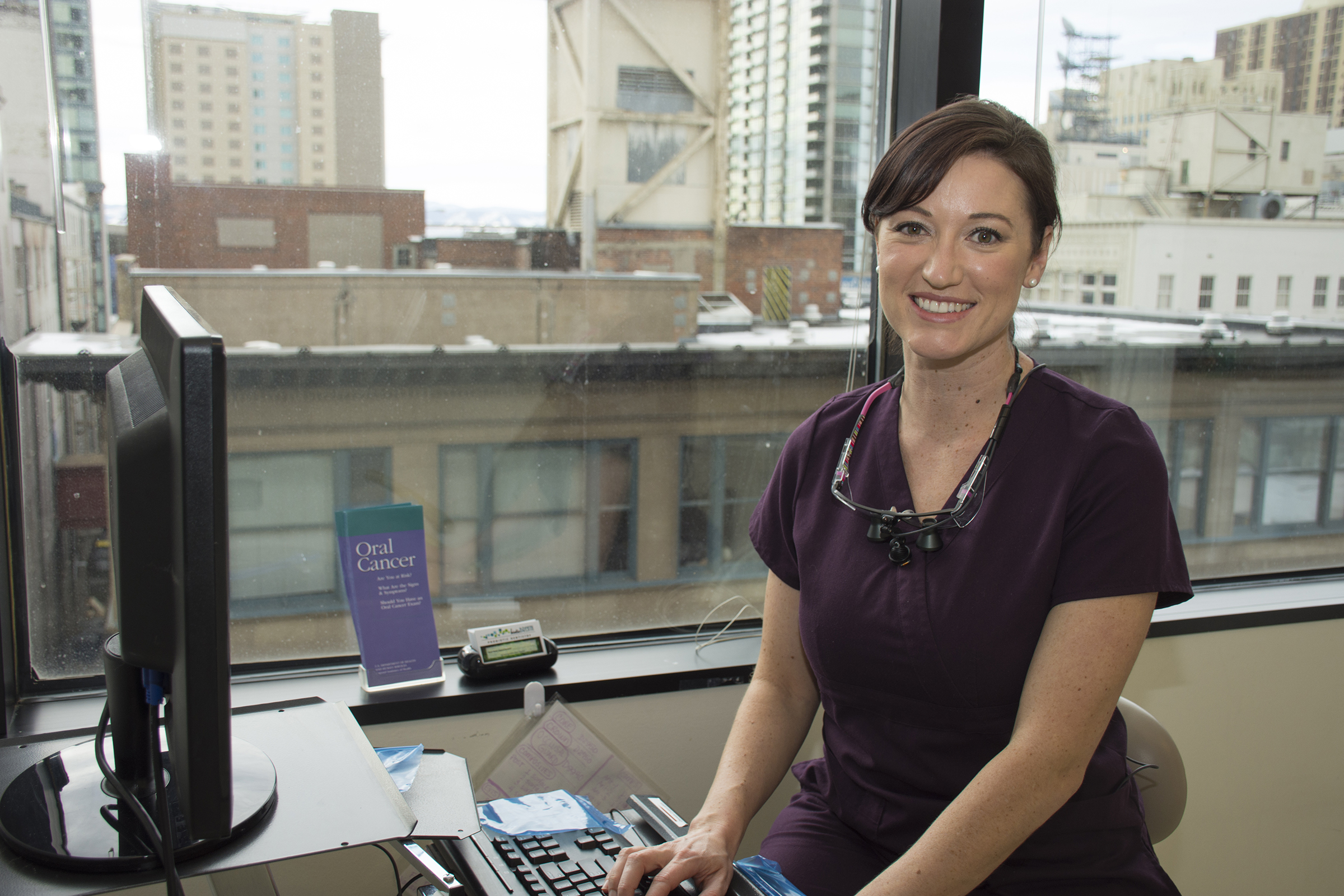 ccd dental student sitting down wearing medical scrubs smiling