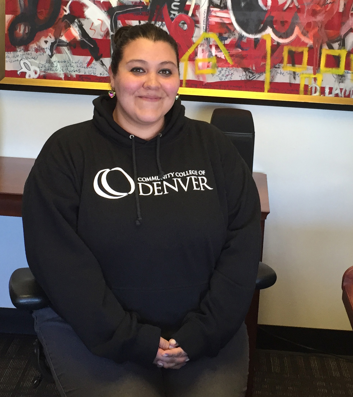 Angela Martinez sitting in the 'President's Chair' woman sitting in a chair smiling