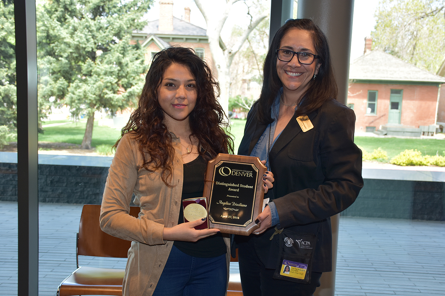 two females holding an award