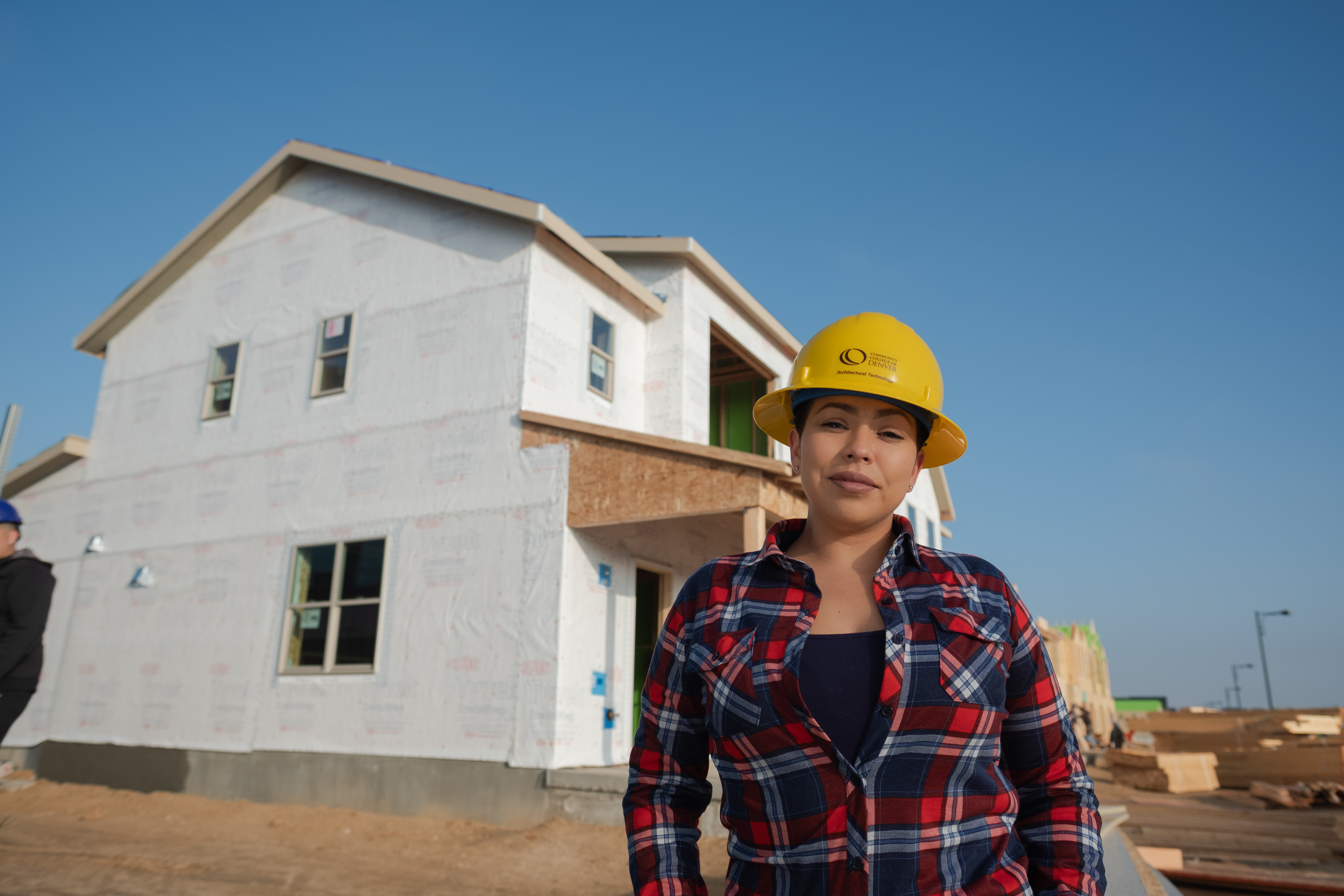 The basic and advanced building crafts certificates can be completed in two semesters. woman in hard hat outside at a construction site