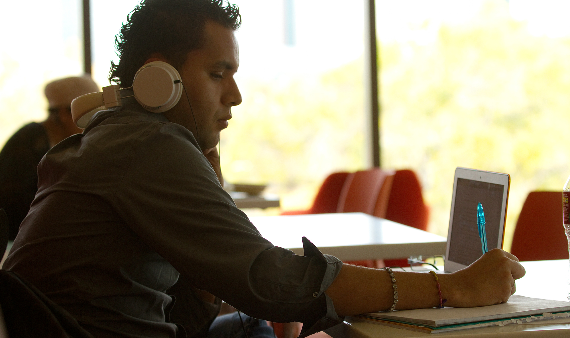 student with headphones at a laptop studying