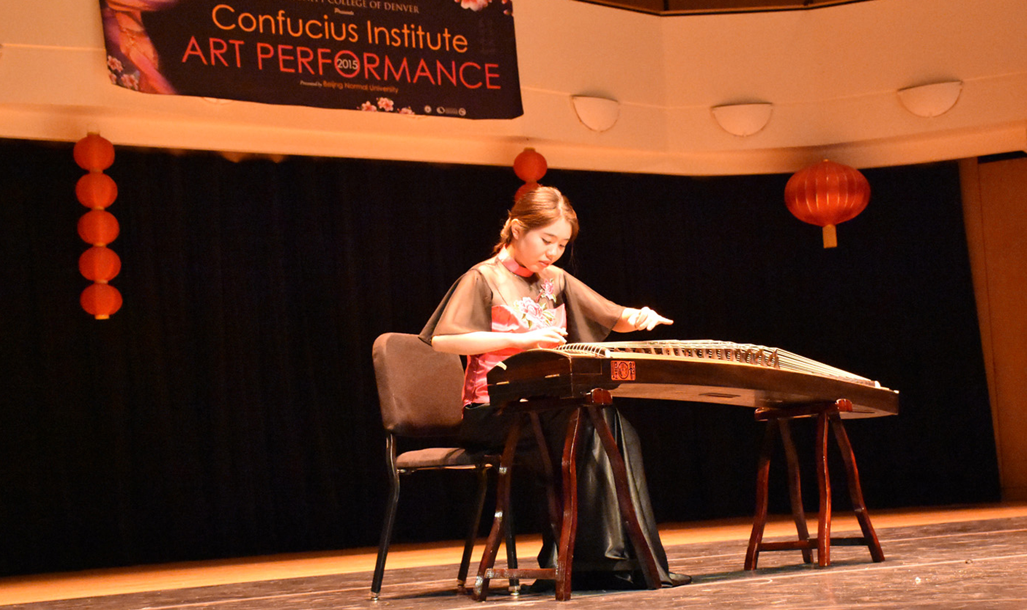 woman on stage plays ancient Chinese instrument