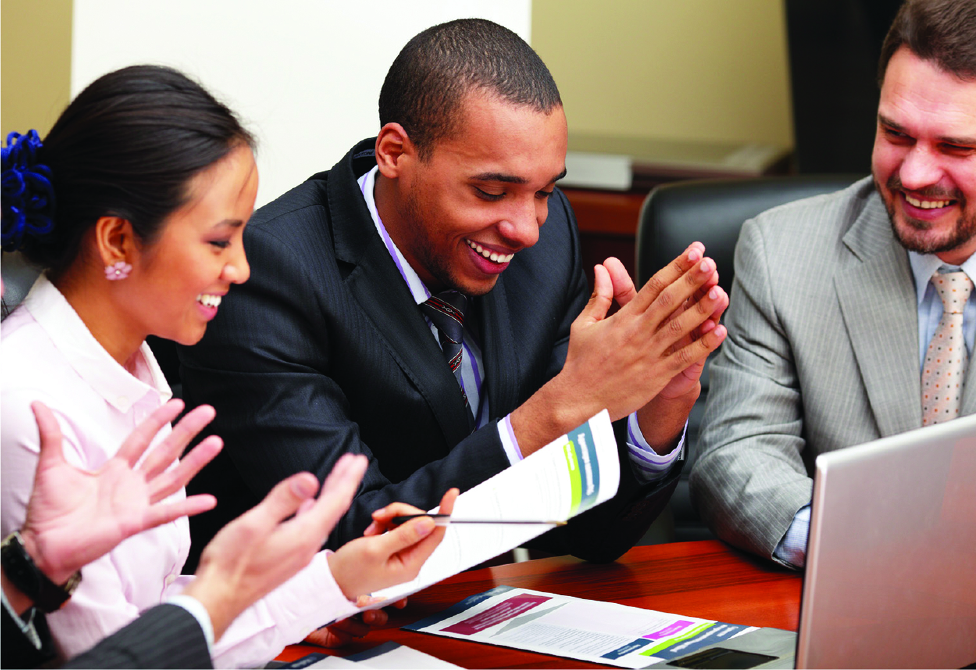 image of a group of people laughing in a business meeting