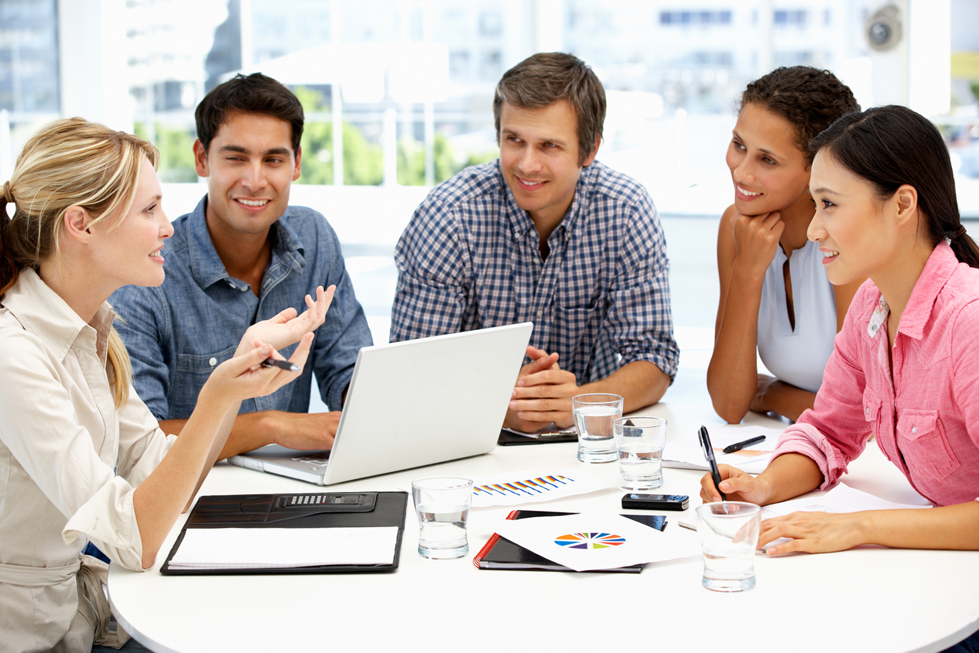 image of a group of five adults looking at graphs and talking