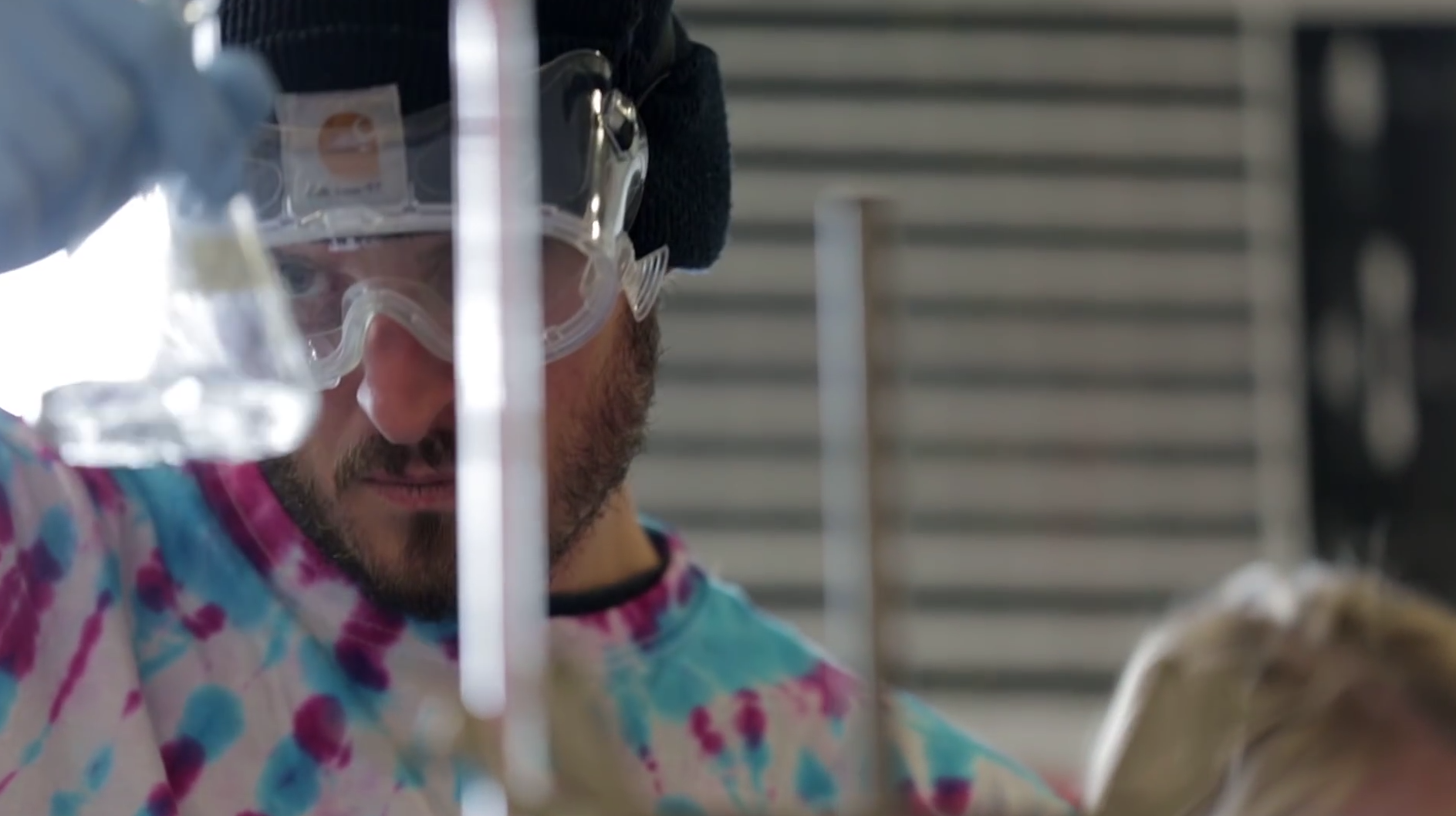 Get an associate of applied science in chemistry young man in chemistry glasses holding a beaker