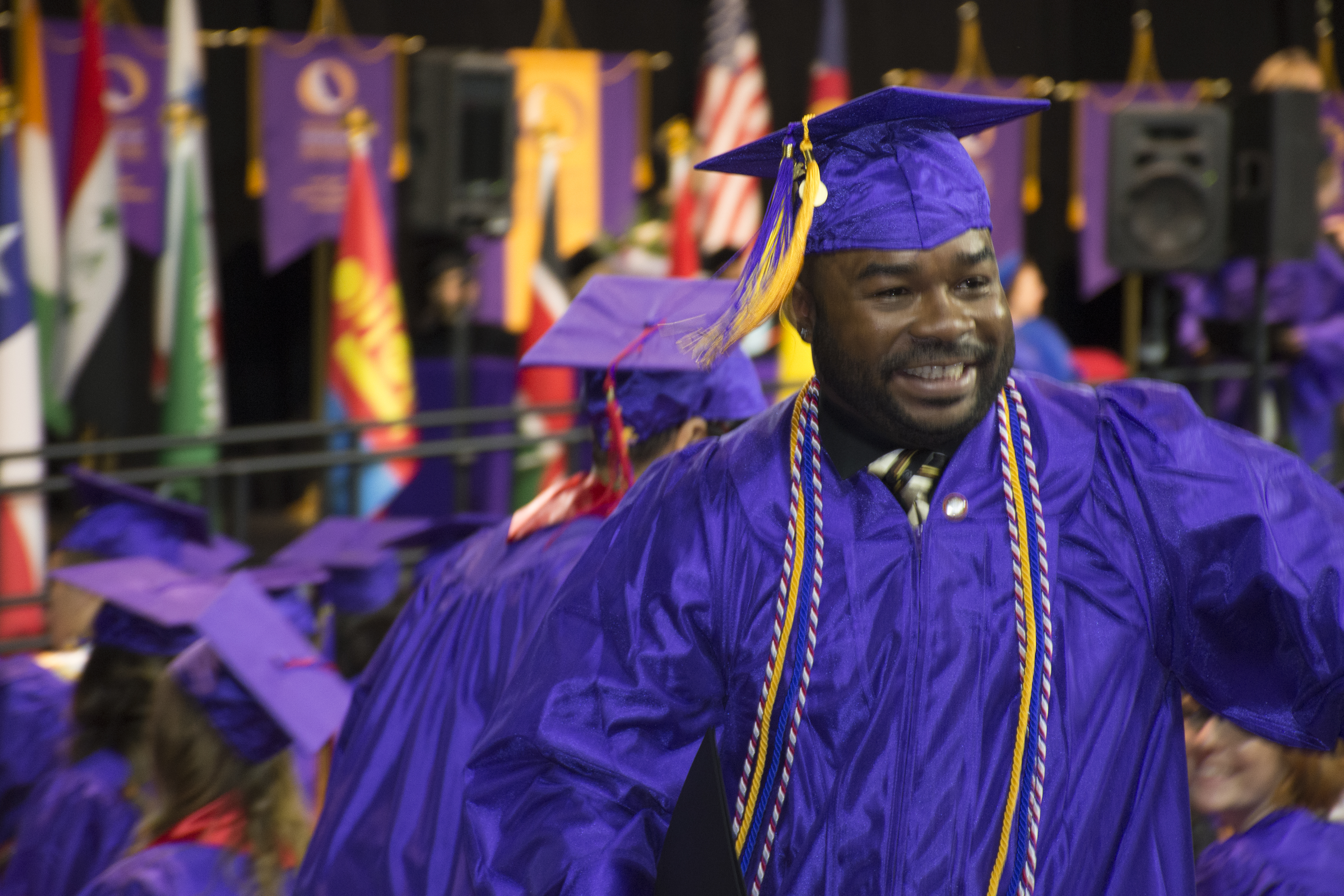 man in cap and gown at commencement