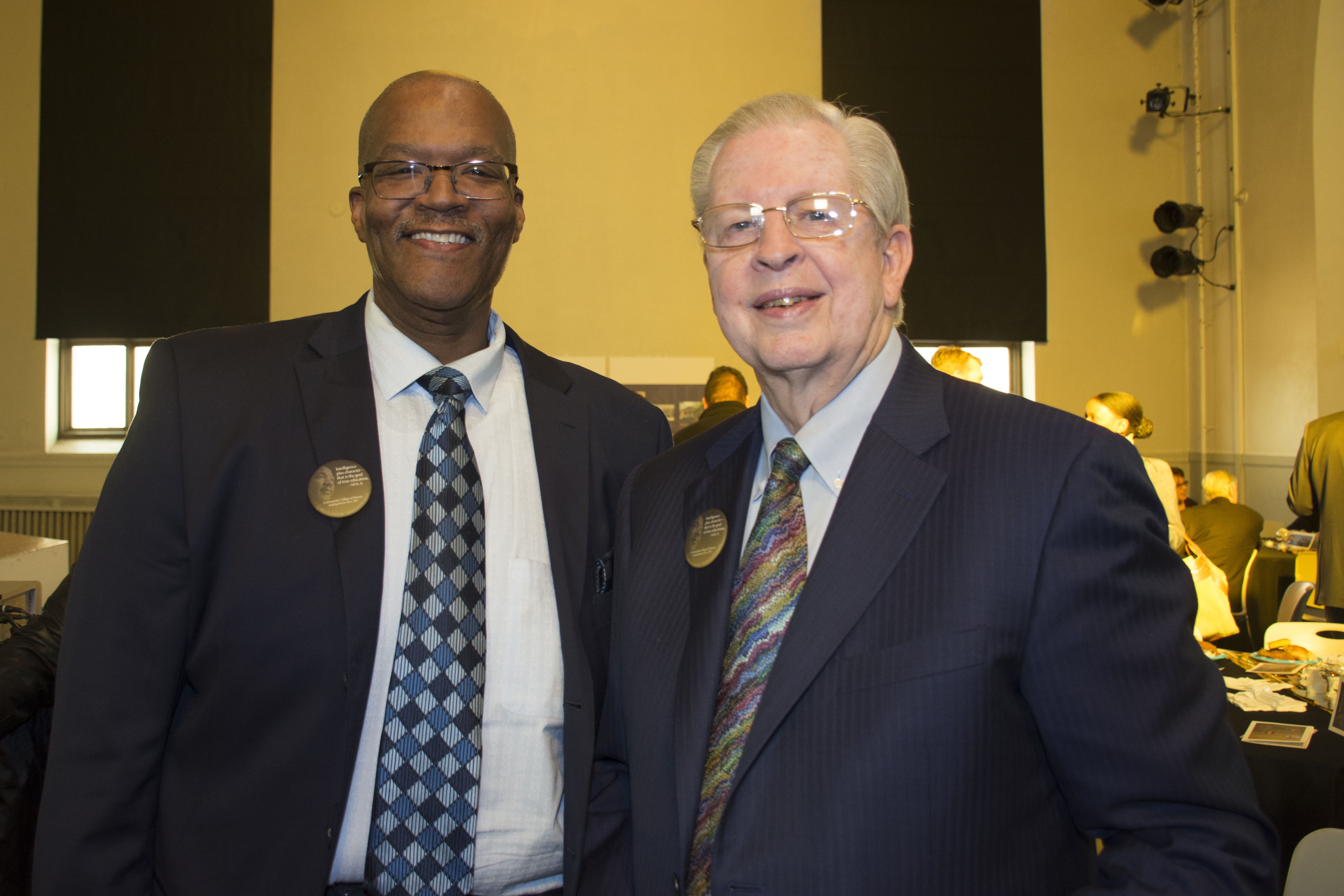 two men wearing suits at an awards ceremony