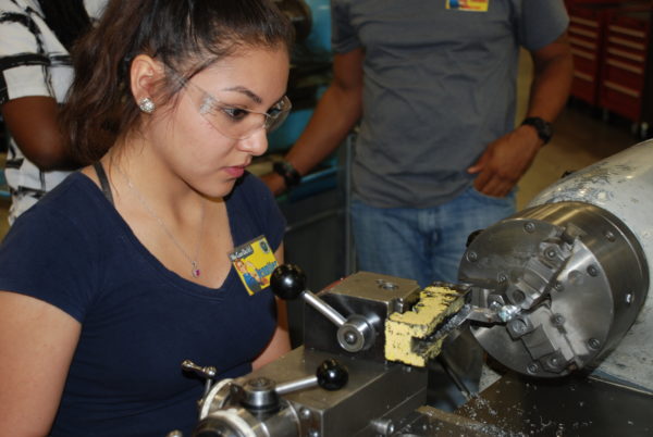 female works on machining equipment