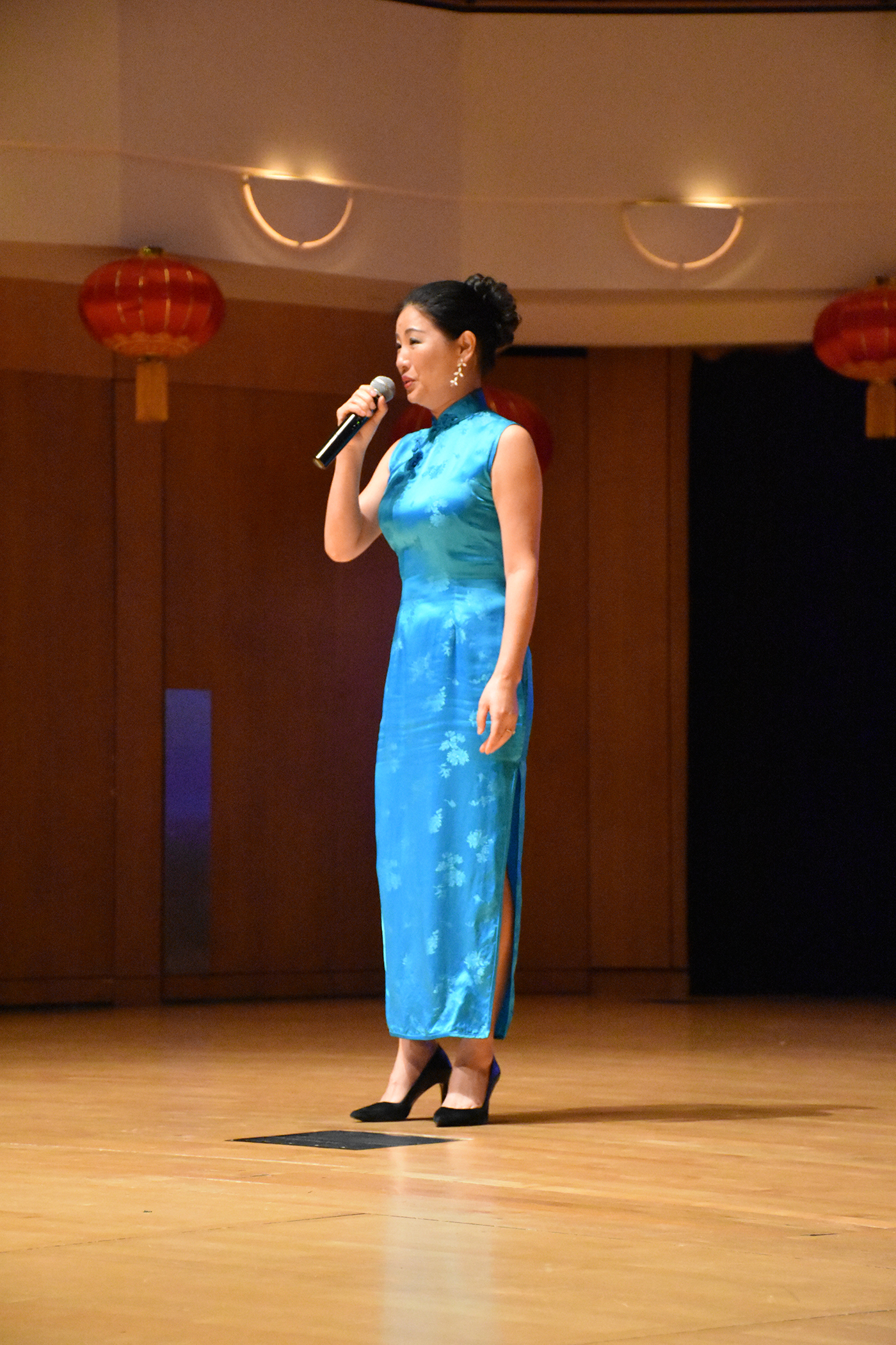 women in blue dress singing on stage