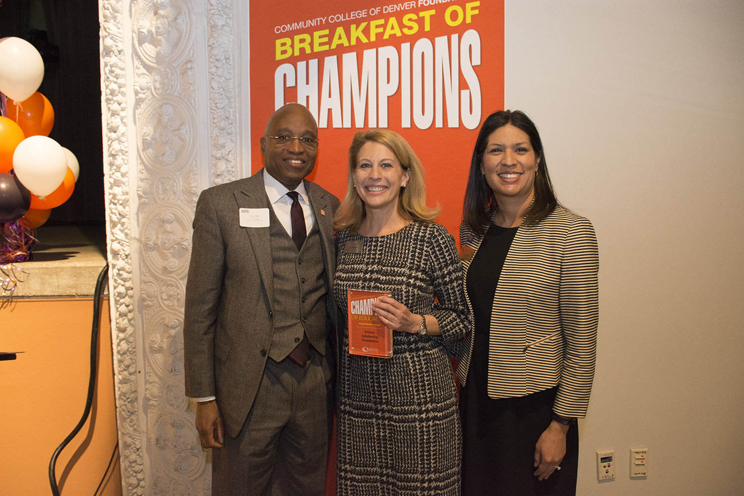The Engagement Champion was awarded to the Denver Scholarship Foundation three people pose at an award function