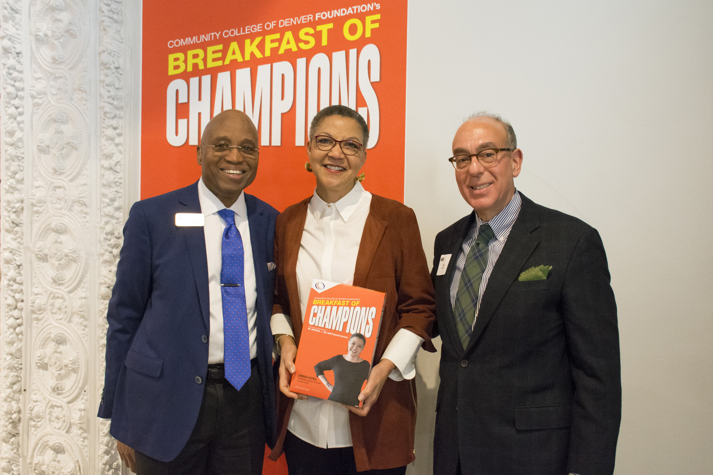 woman holding a Breakfast of Champions cereal box next to two men in suits