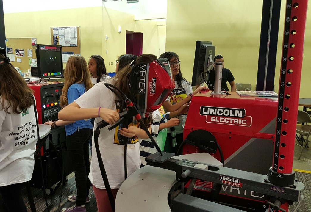 female students practice with welding machine stimulators