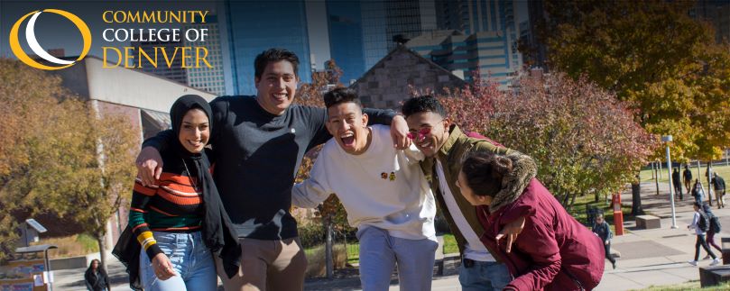 Five students sitting on stairs holding a laptop