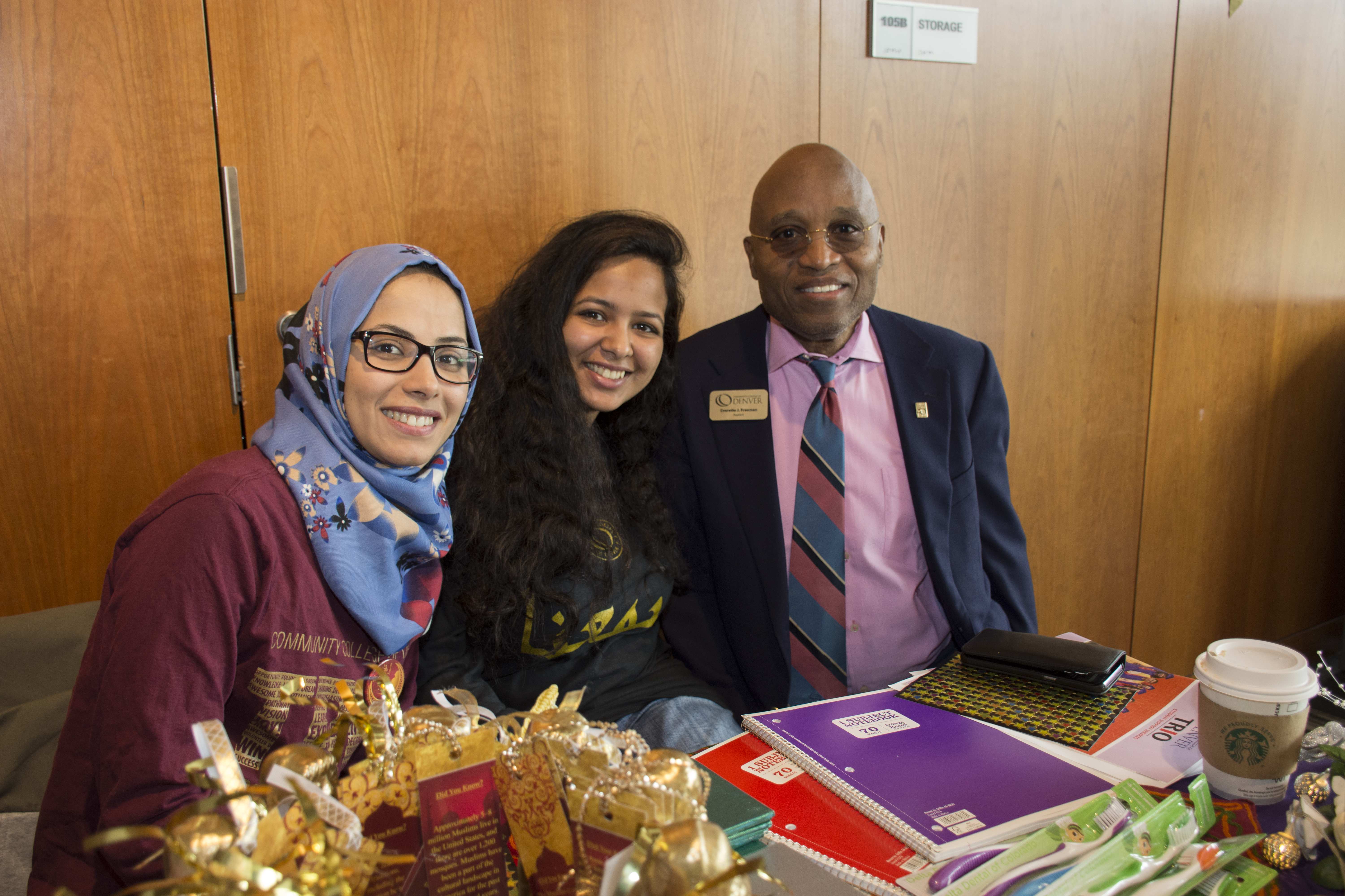 Dr Freeman with event attendees two females and a man at an info table