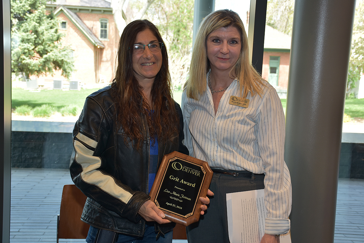 CCD Provost Rhonda Epper awarding Lisa Marie Fertman a plaque two women standing holding a plaque