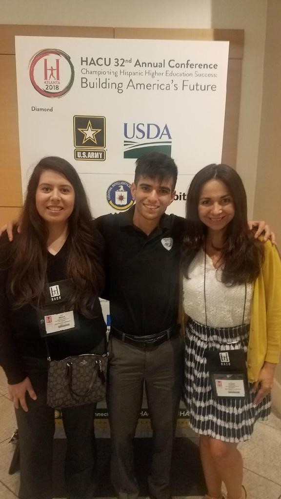 HACU Hispanic Association of Colleges & Universities Two Females With Male in Front of Sign
