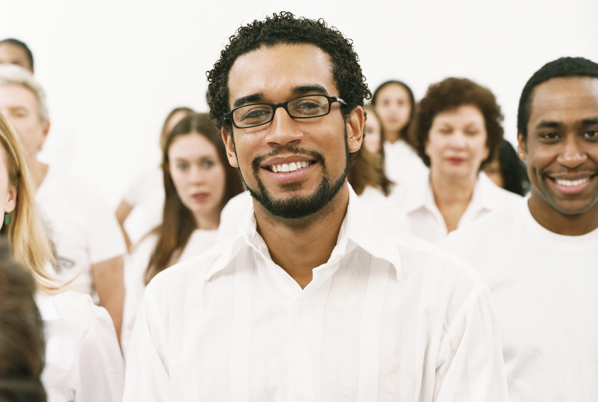 A diverse group of people all wearing white shirts