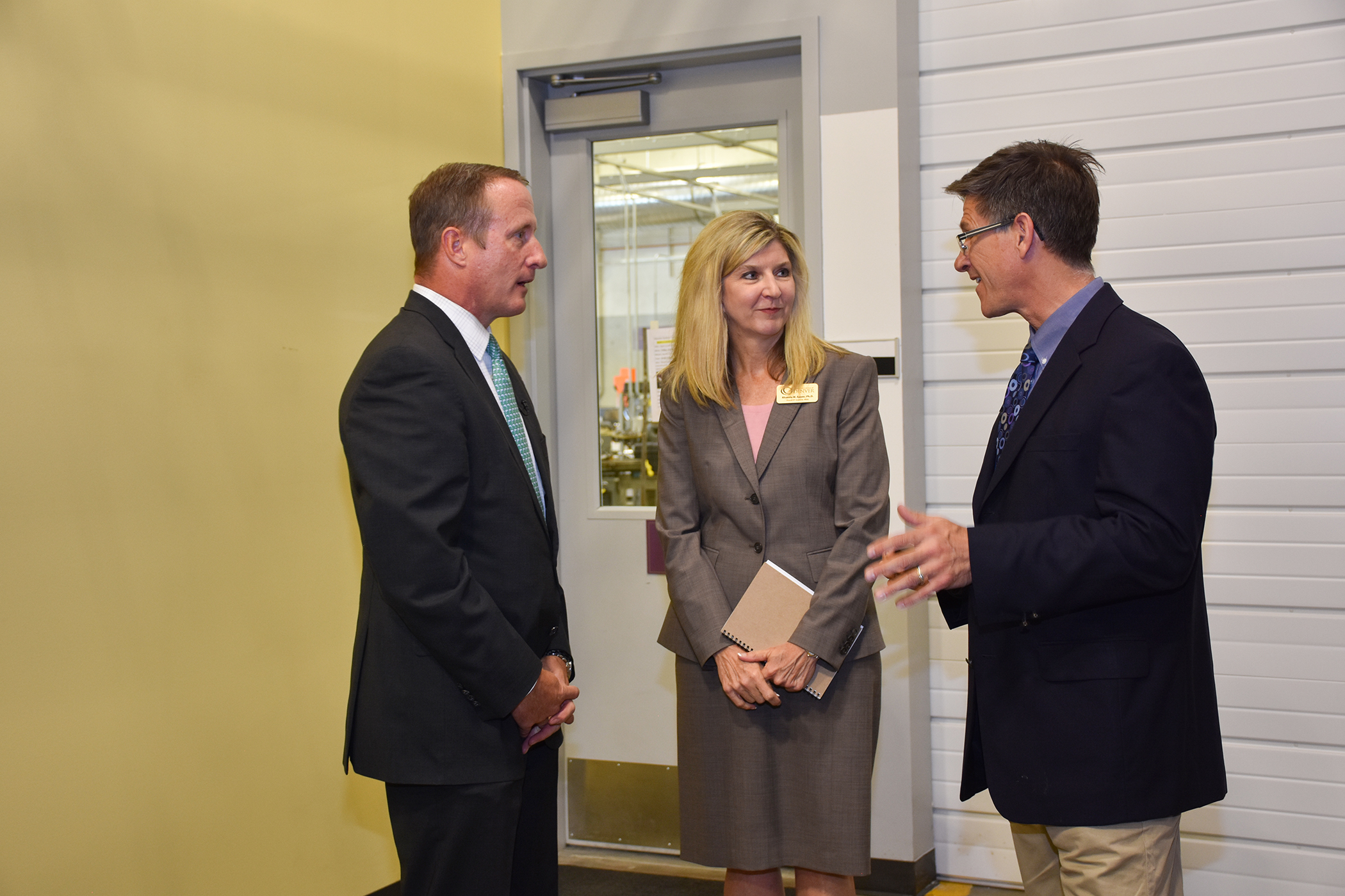 2 men and a woman standing talking