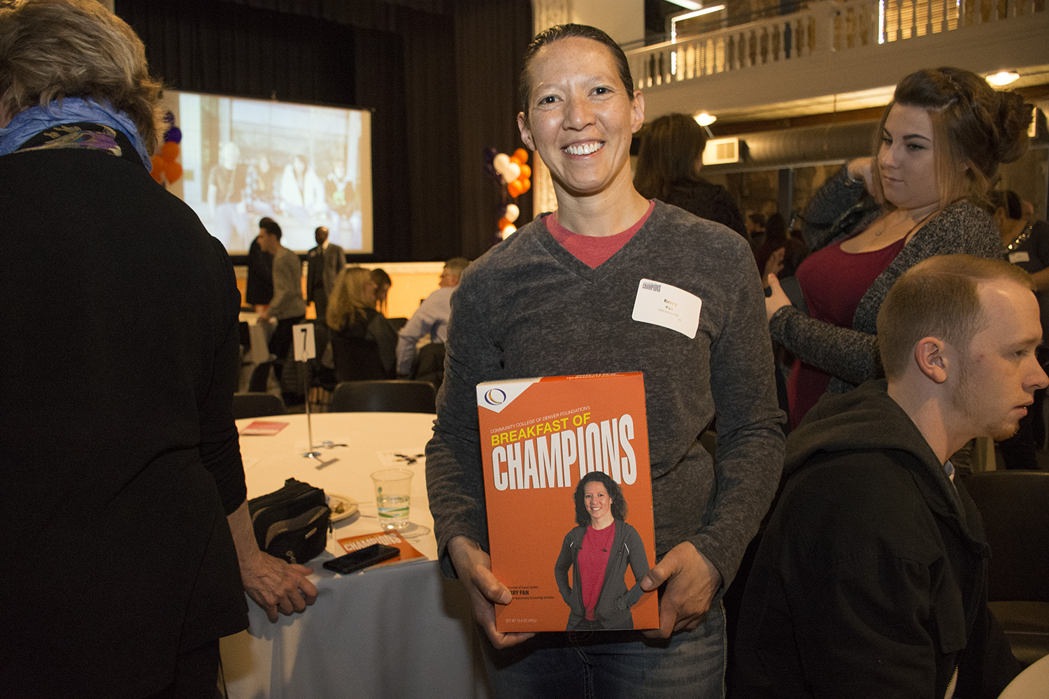 CCD Associate of Science Student Kerry Pan, Colorado Opportunity Scholarship Initiative young woman holding a box with her picture on it