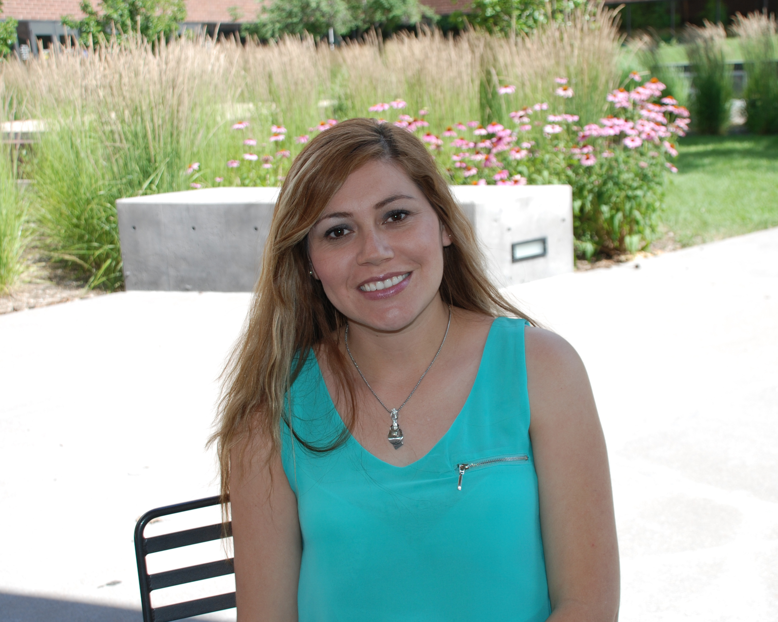 woman sitting outside with flowers in background