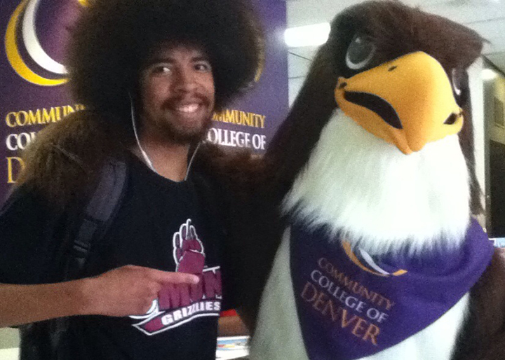 black man standing next to CCD mascot Swoop