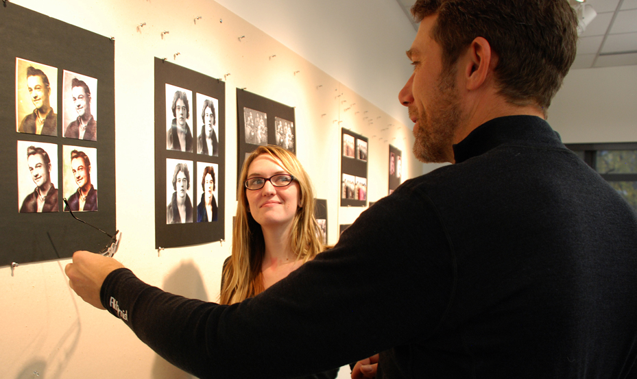 man and woman discuss the graphic image on the wall created by graphic designer