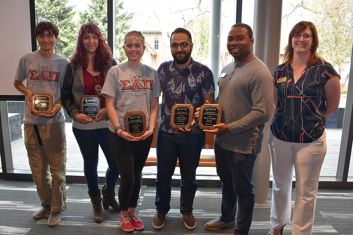 group of 6 college students holding plaques