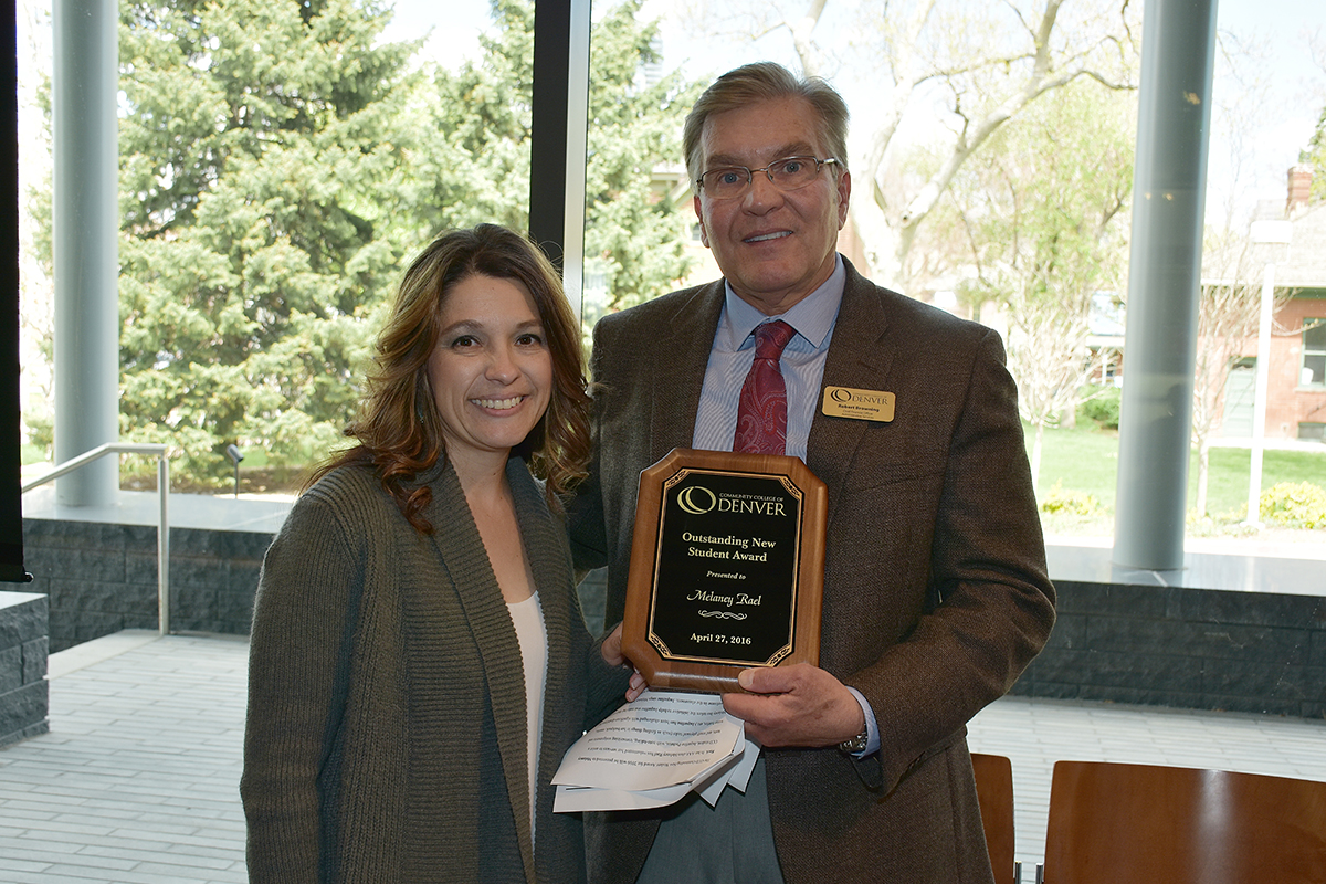 VP Bob Browning Presents CCD Student Melaney Rael with an Award A woman and man holding a plague