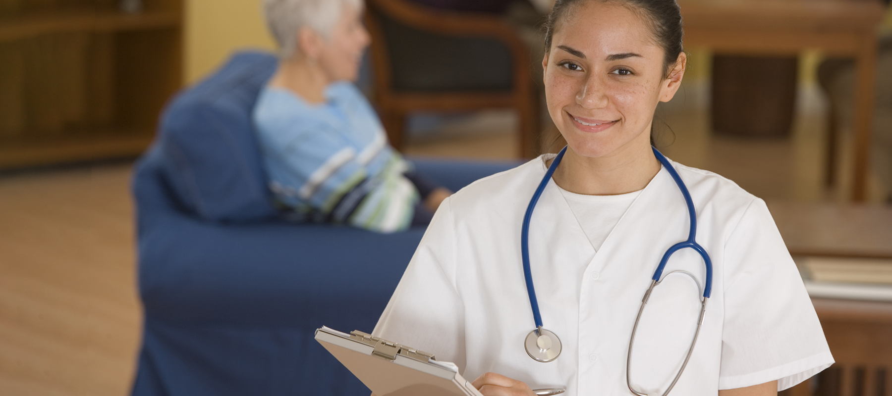 young Hispanic nurse wearing a white shirt and a stethscope