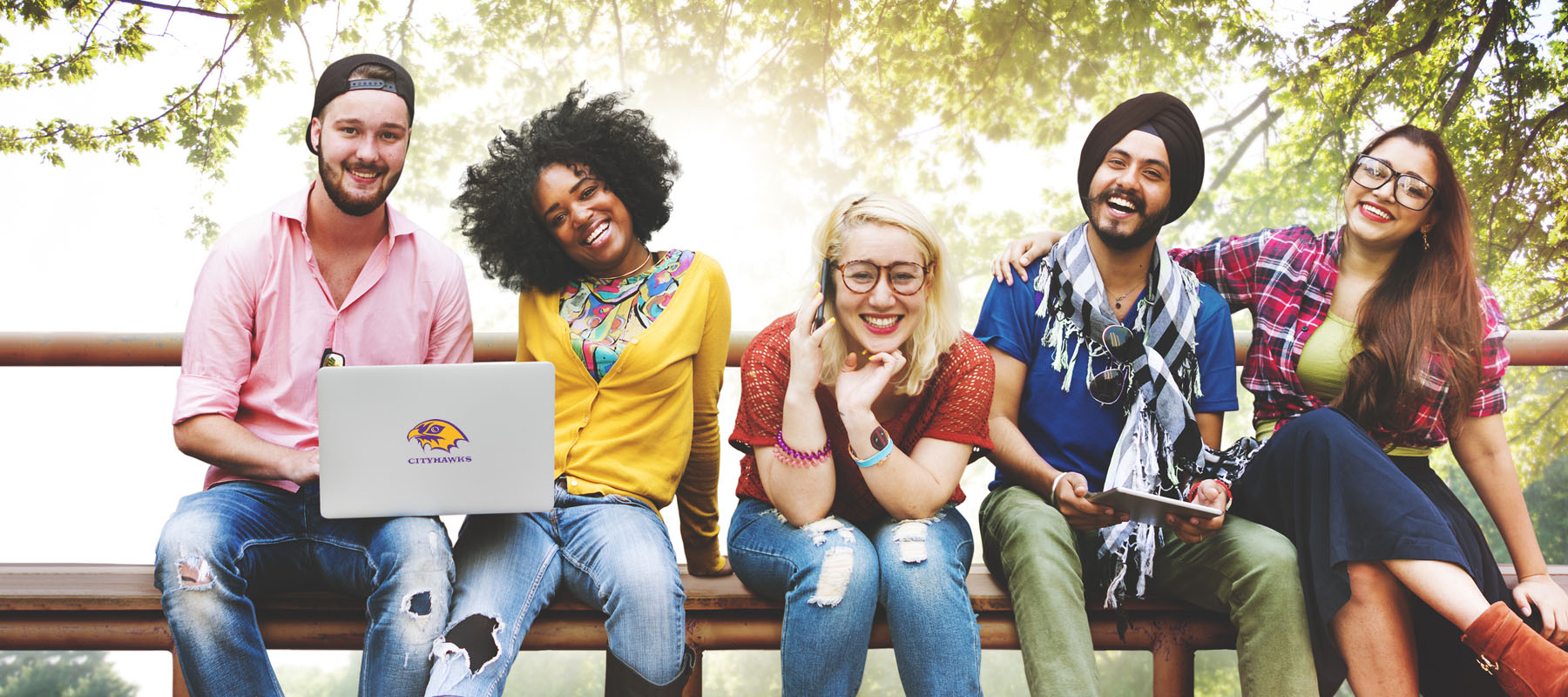 five students sitting on a bench outside