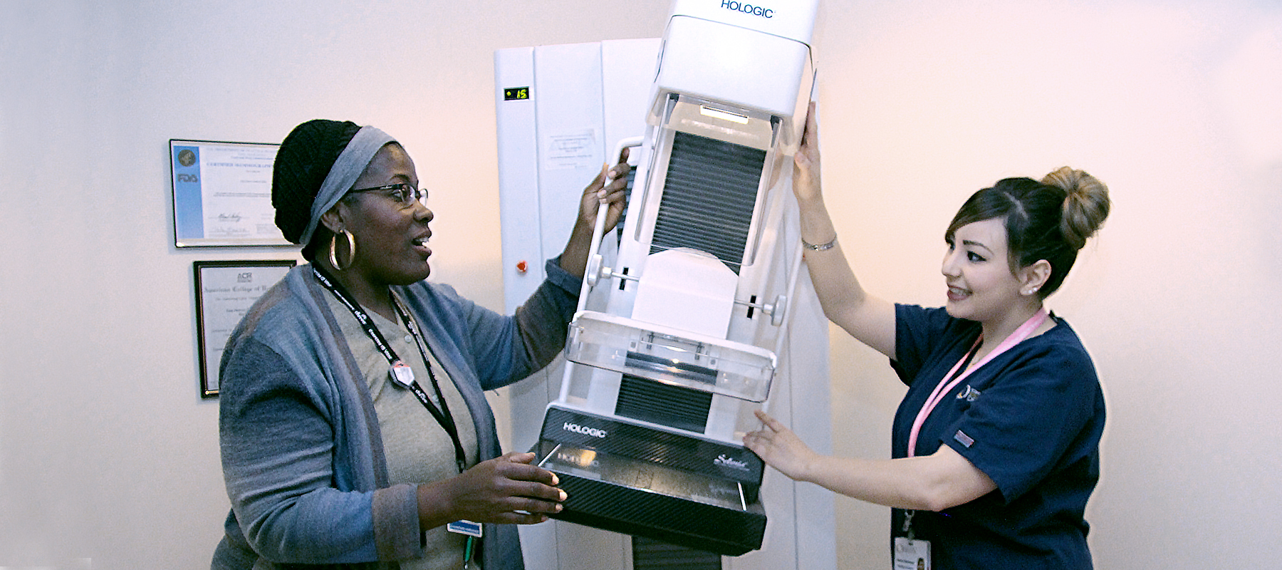 two women working with a mammography machine