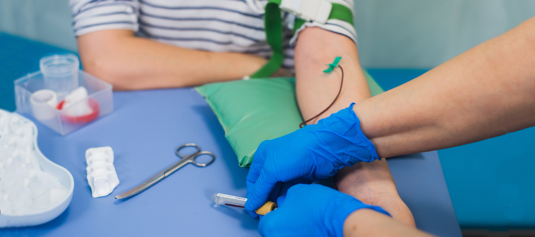 nurse drawing blood from a patient's arm