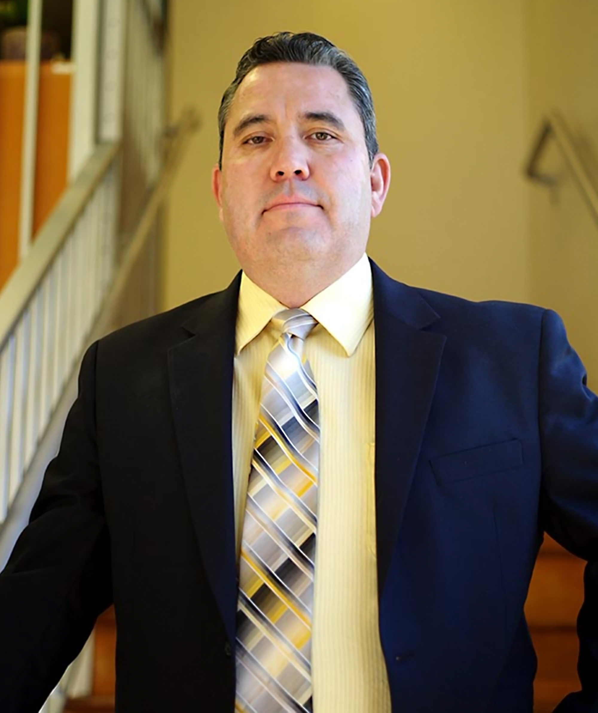 Hispanic man standing in a stairwell smiling