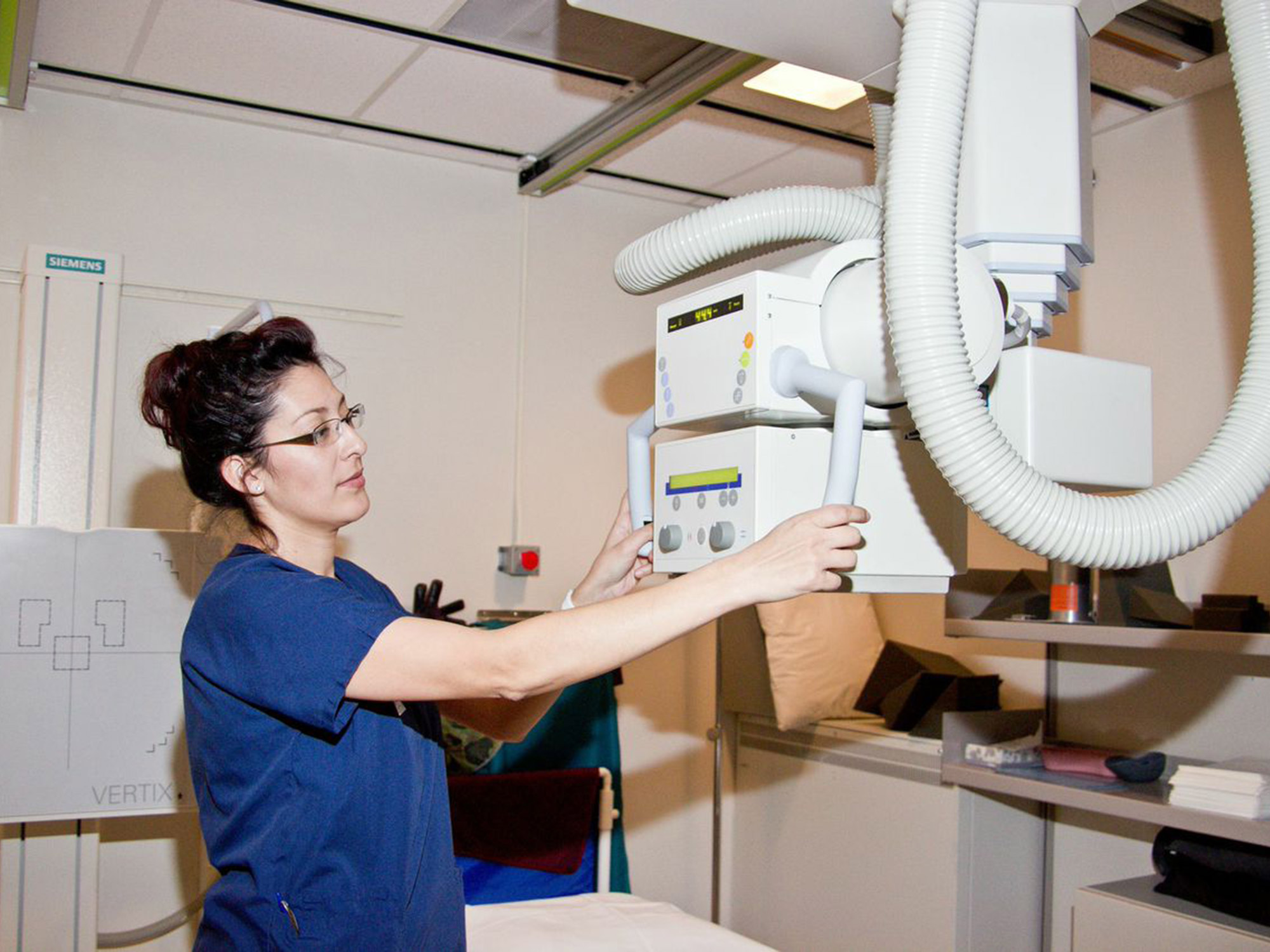 A female Radiologic Technologist prepares to take x-rays.