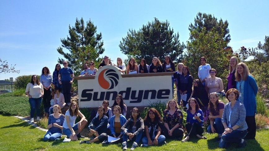 group of people in front of a sign that reads Sundyne