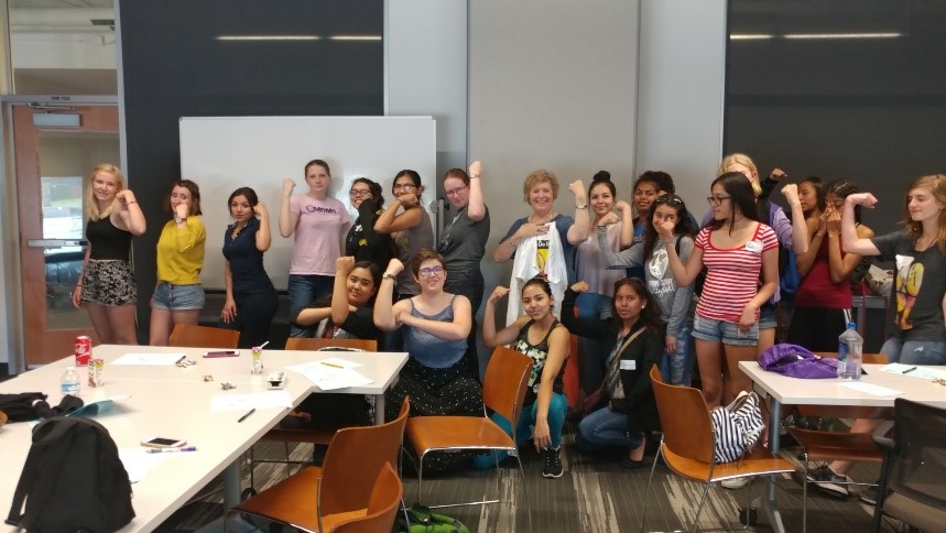 group of girls displaying the Rosie the Riveter pose.