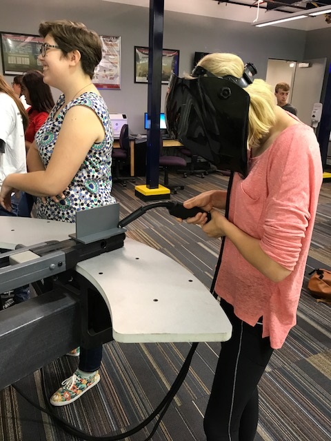 female in protective helmet tries a simulator