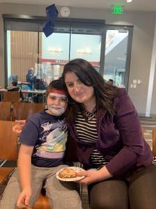 Mom in a purple coat and son with his face painted as Santa