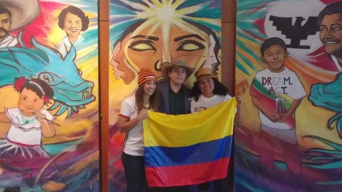Two students and staff with the Colombian Flag Representing Colombia at the CCD Somos event