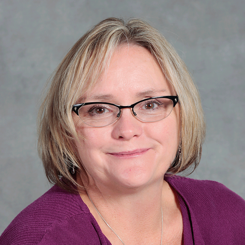 Smiling woman with glasses in a purple shirt